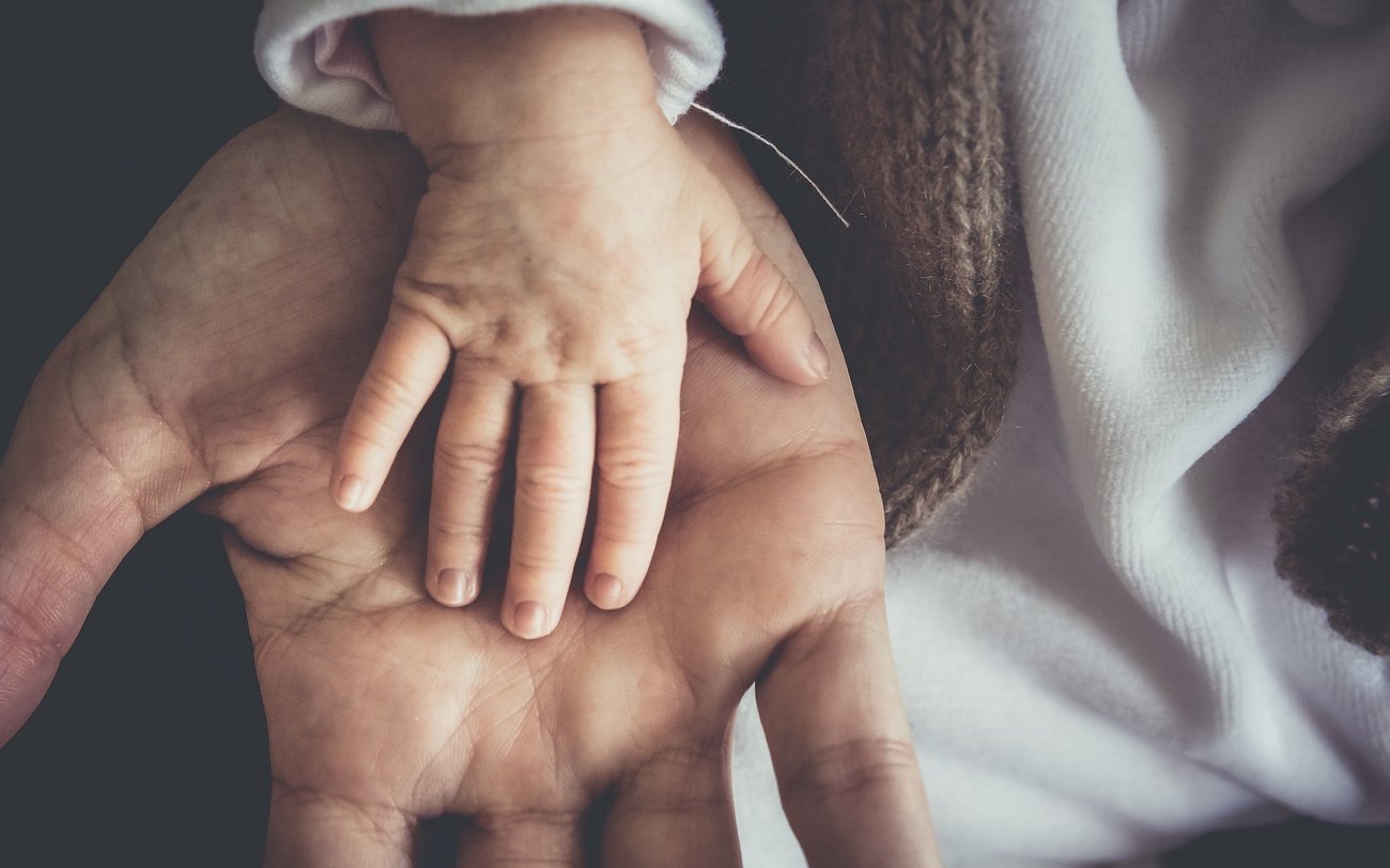 Main d'un adulte et main d'un enfant